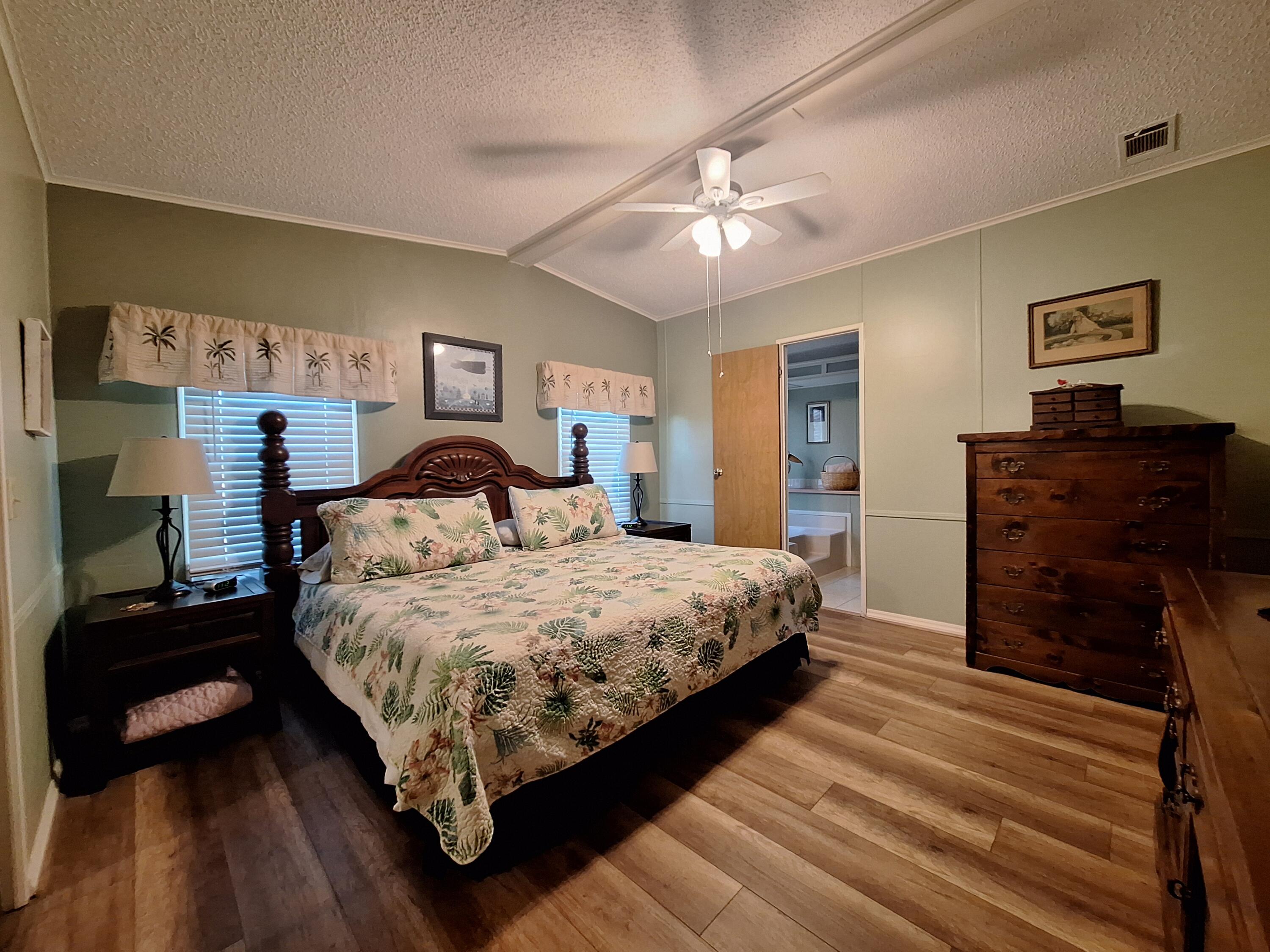 846 Periwinkle Circle Barefoot Bay, FL 32976 - Photo 15 of 23 a bedroom with a bed and wooden floor