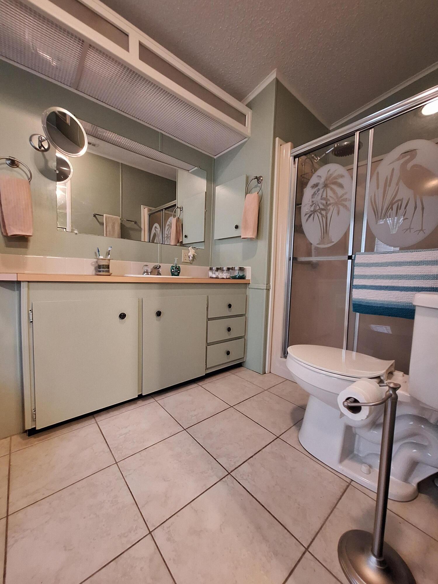 846 Periwinkle Circle Barefoot Bay, FL 32976 - Photo 23 of 23 a bathroom with a sink a toilet and a mirror