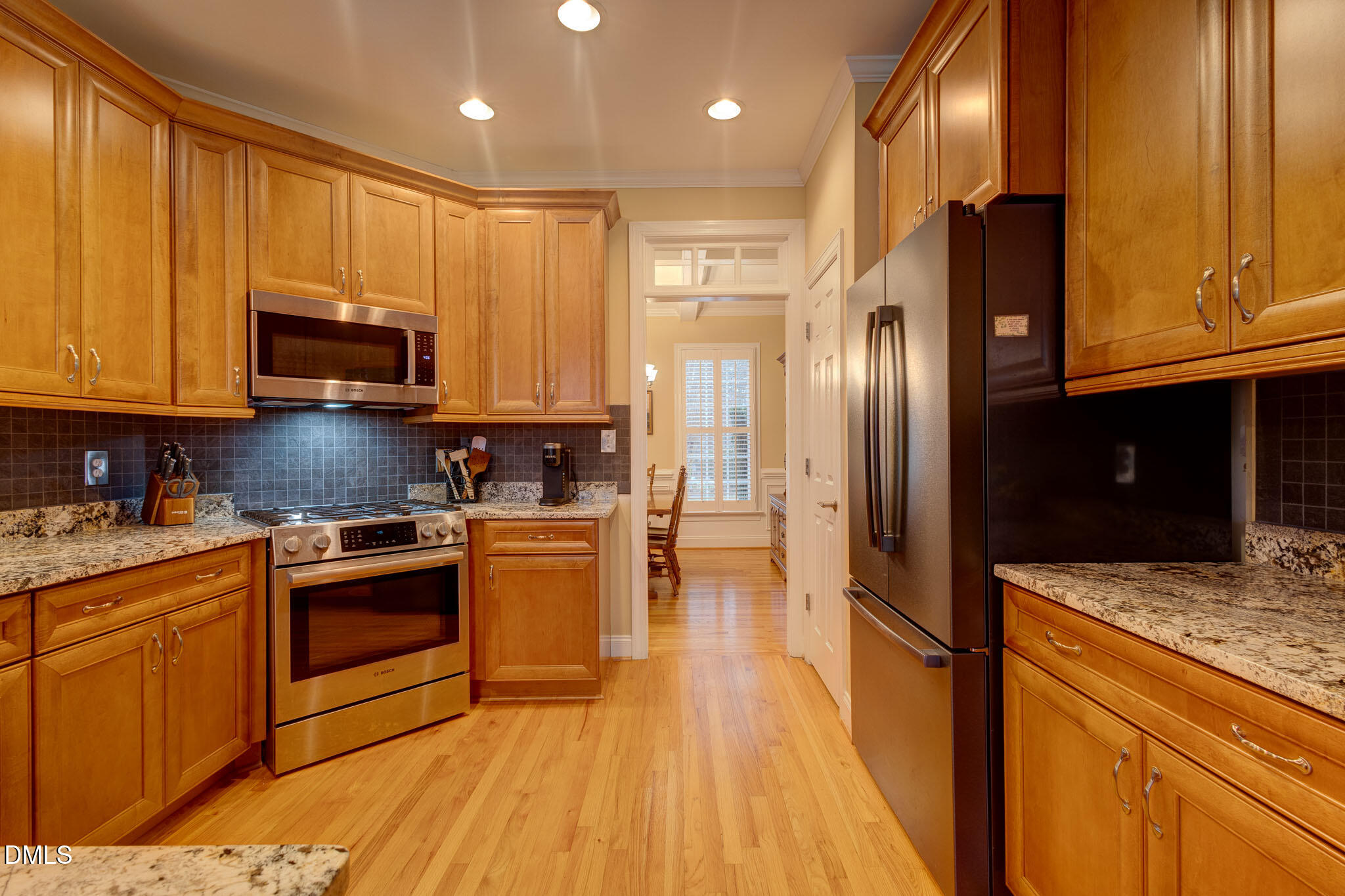 1116 Neuse Ridge Drive Clayton, NC 27527 - Photo 14 of 39 a kitchen with stainless steel appliances granite countertop wooden cabinets a refrigerator a stove a sink and dishwasher with wooden floor