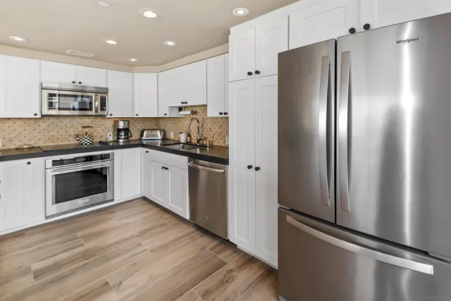 a kitchen with stainless steel appliances granite countertop a refrigerator and a stove top oven