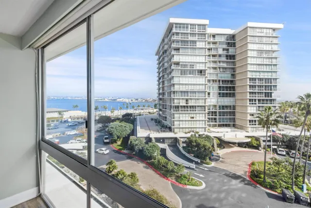 a view of balcony with a couple of cars parked in parking lot