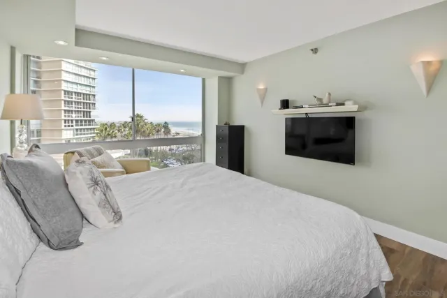 a bedroom with a bed a large window and mirror