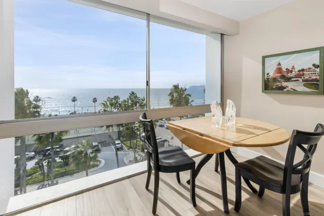 a view of a dining room with furniture one side kitchen view and wooden floor