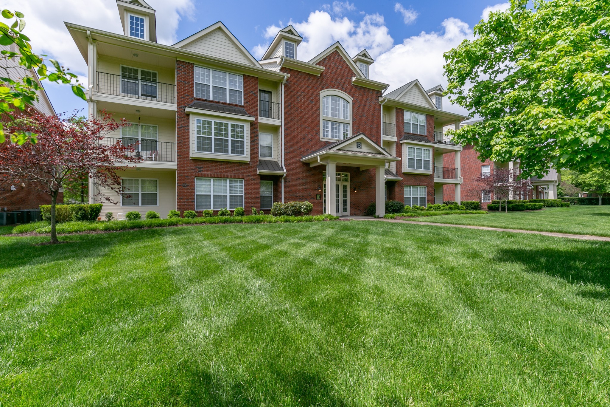 3201 Aspen Grove Drive, Unit B9 Franklin, TN 37067 - Photo 1 of 37 a front view of a building with a garden