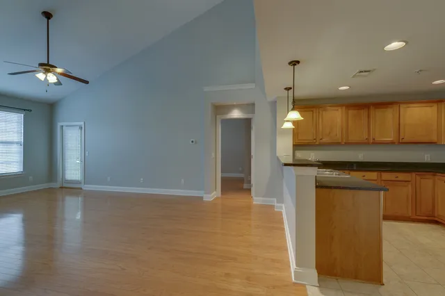 a view of a kitchen with a sink and dishwasher with wooden floor