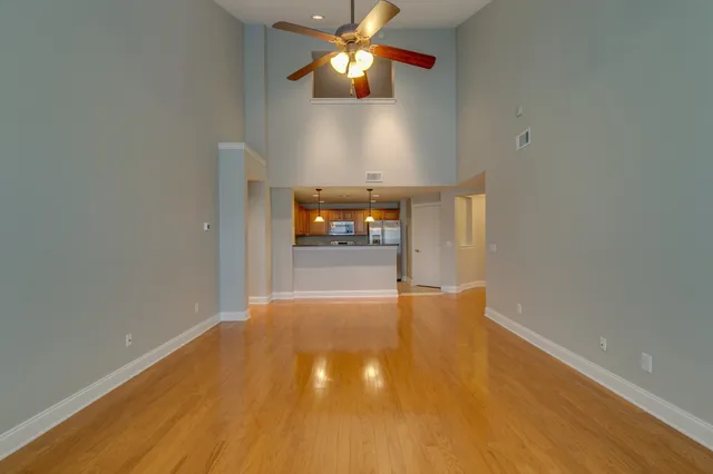 a view of an empty room and chandelier fan