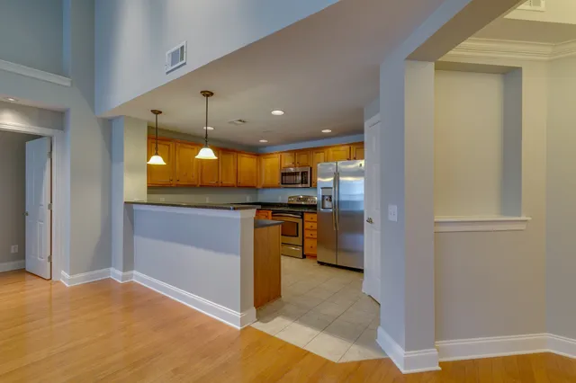 a view of kitchen with kitchen island granite countertop a refrigerator and a sink