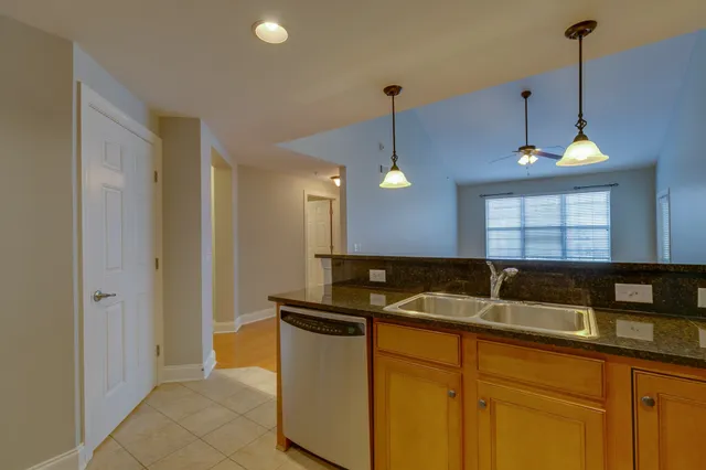 a kitchen with granite countertop a sink a counter and cabinets