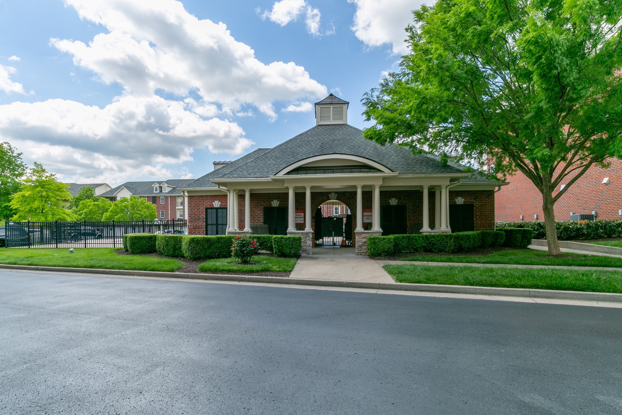3201 Aspen Grove Drive, Unit B9 Franklin, TN 37067 - Photo 33 of 37 a view of a brick house next to a yard with big trees