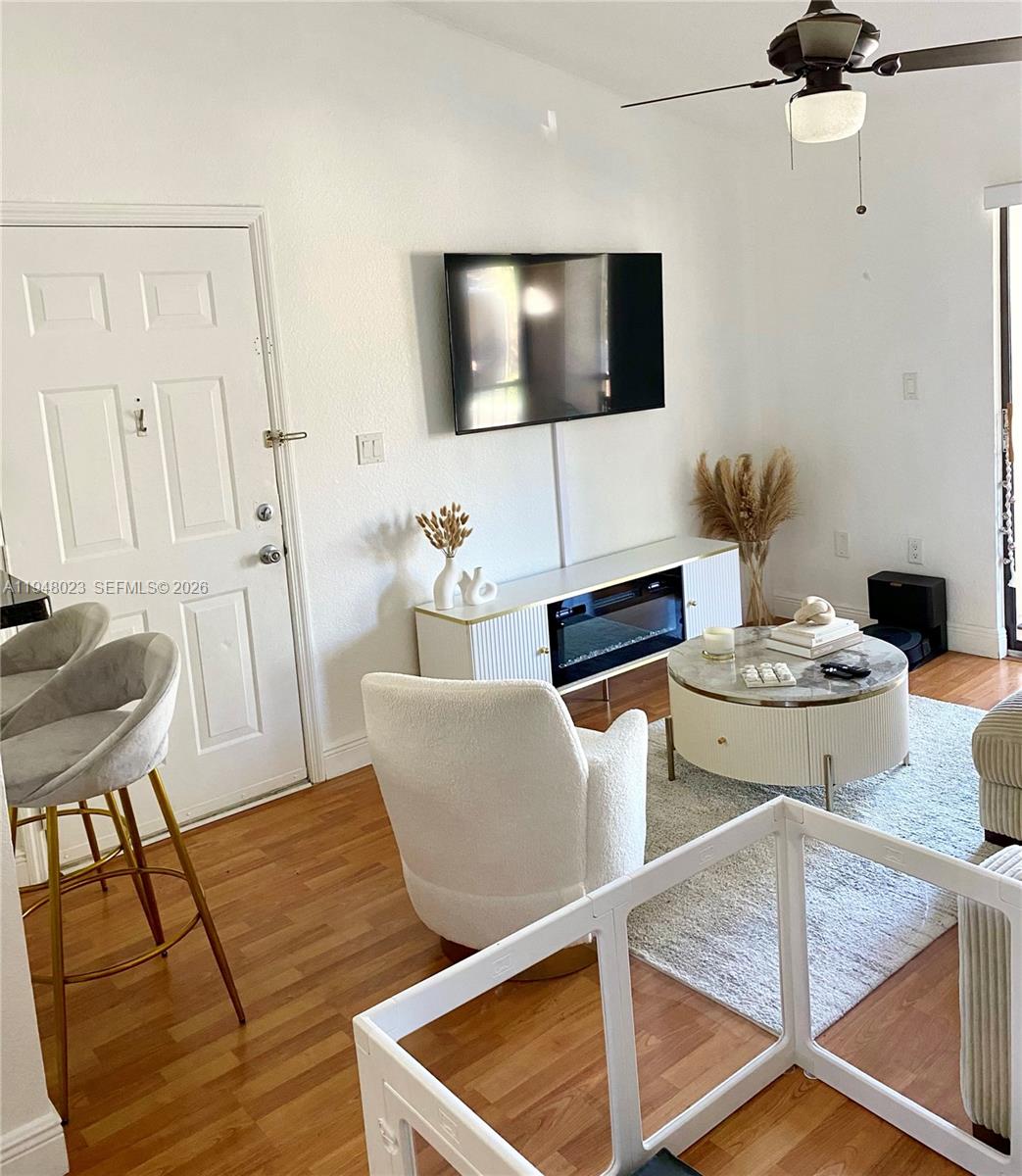 15680 Southwest 106th Lane, Unit 804 Miami, FL 33196 - Photo 14 of 32 a living room with furniture and a flat screen tv