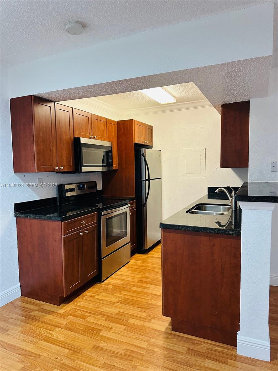 15680 Southwest 106th Lane, Unit 804 Miami, FL 33196 - Photo 17 of 32 a kitchen with stainless steel appliances granite countertop a stove a sink and a refrigerator