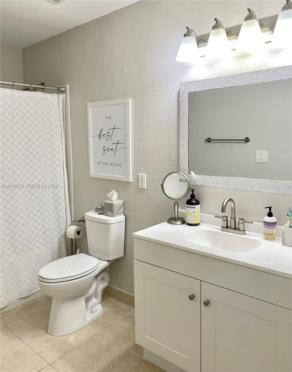 15680 Southwest 106th Lane, Unit 804 Miami, FL 33196 - Photo 20 of 32 a bathroom with a toilet sink and mirror