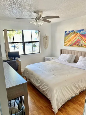 a bedroom with a bed and a flat tv screen on dresser