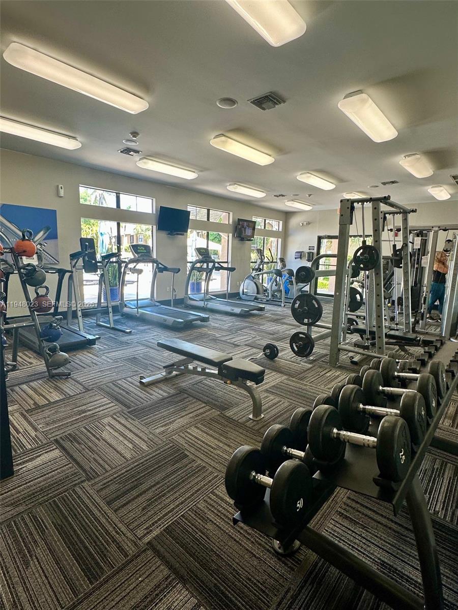 15680 Southwest 106th Lane, Unit 804 Miami, FL 33196 - Photo 7 of 32 a view of a room with lots of gym equipment