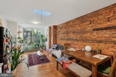a living room with furniture a rug and a floor to ceiling window