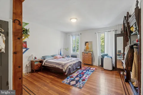 a bedroom with bed and wooden floor