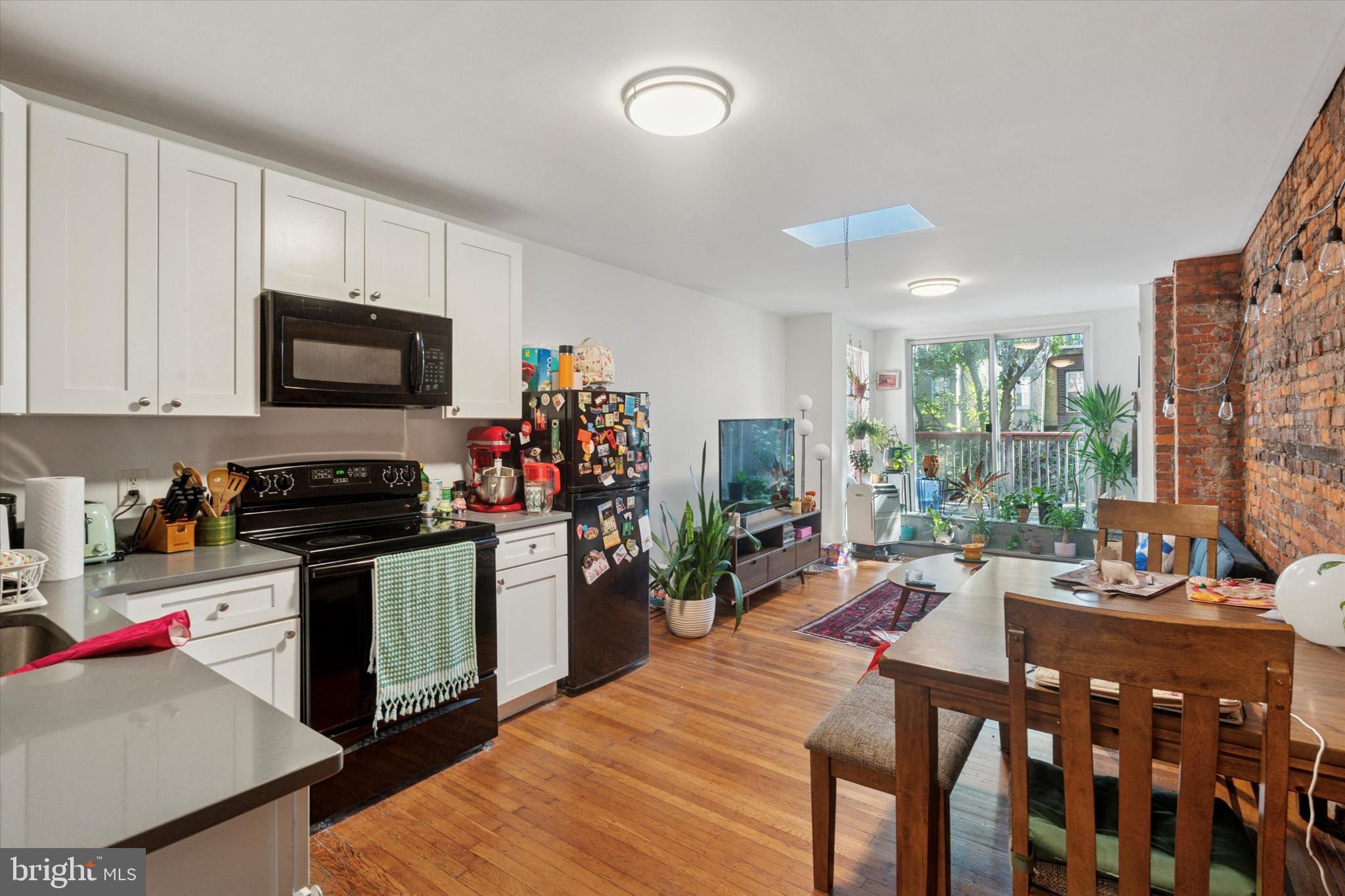3816 Spring Garden Street Philadelphia, PA 19104 - Photo 2 of 30 a kitchen with stainless steel appliances stove microwave refrigerator dining table and chairs