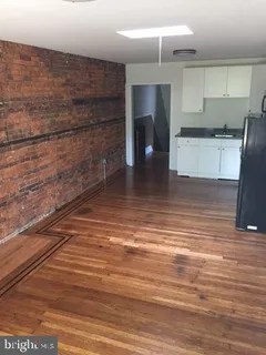 a view of empty room with kitchen and window