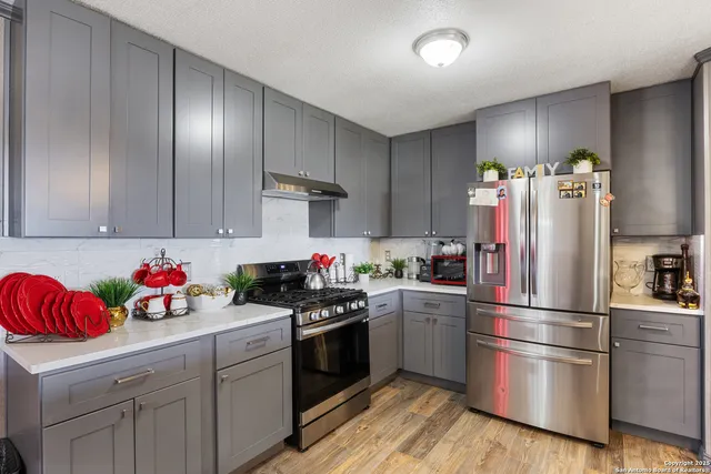 a kitchen with a refrigerator and wooden floor