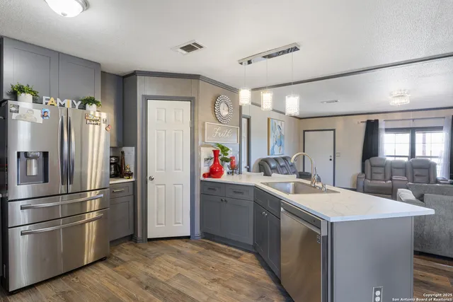 a kitchen with a sink refrigerator and cabinets