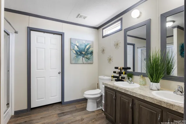 a bathroom with a granite countertop sink toilet a mirror a vanity and shower