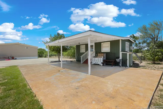 a backyard of a house with table and chairs