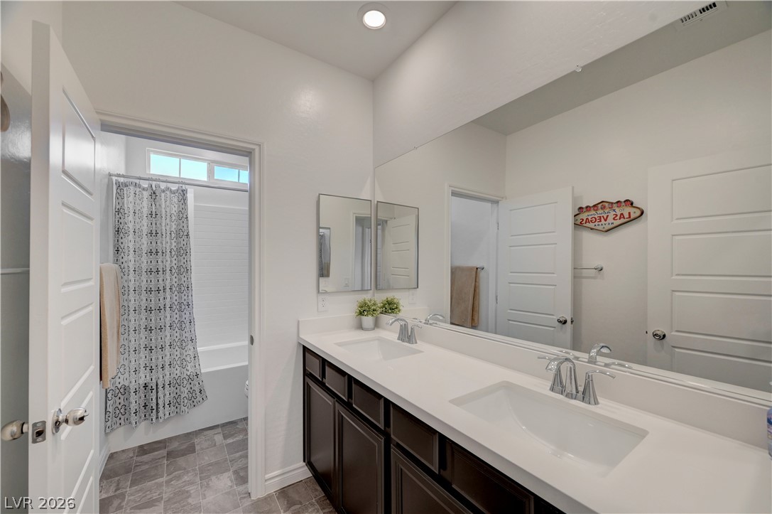 7204 North Decatur Boulevard, Unit 3 North Las Vegas, NV 89084 - Photo 31 of 48 Dual vanities with modern fixtures and a spacious mirror create a functional and stylish primary bathroom.