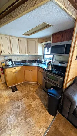 a kitchen with stainless steel appliances granite countertop a stove a sink and a microwave