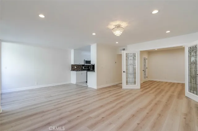 a view of empty room with wooden floor