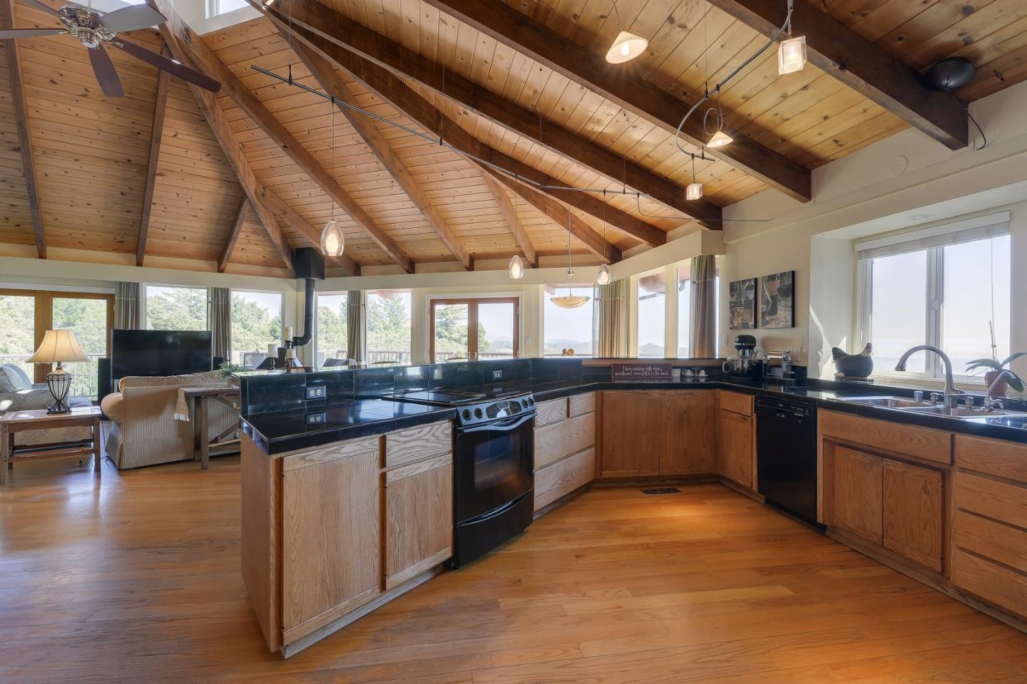 18503 Favre Ridge Road Los Gatos, CA 95033 - Photo 17 of 40 a large kitchen with a stove and a dishwasher with couches