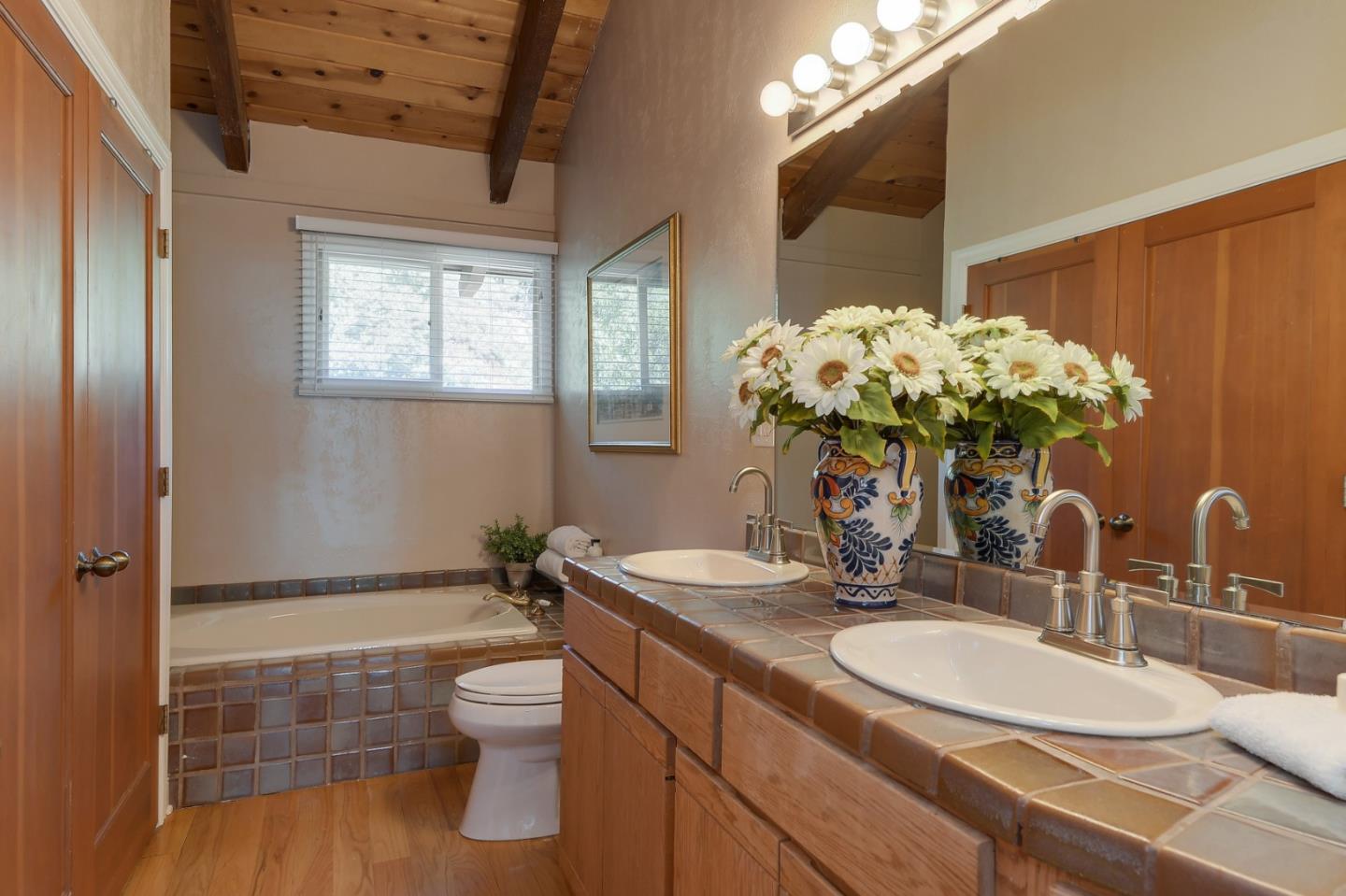 18503 Favre Ridge Road Los Gatos, CA 95033 - Photo 23 of 40 a bathroom with a double vanity sink toilet and a mirror