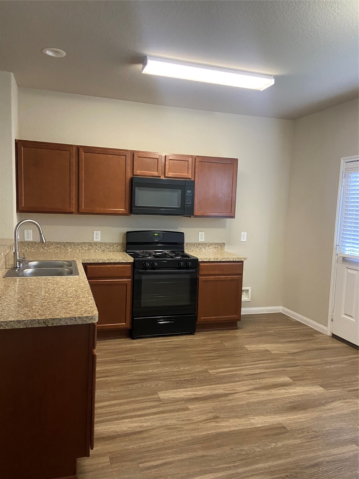 18614 Cooper Ravine Way Katy, TX 77449 - Photo 5 of 9 a kitchen with stainless steel appliances granite countertop a stove a sink and a microwave