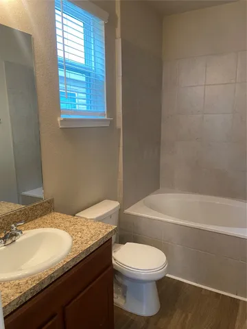 a bathroom with a granite countertop toilet a sink and bathtub