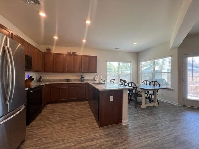 20 Pippin Place Northeast Rome, GA 30165 - Photo 16 of 25 Kitchen with a peninsula, black appliances, dark wood-type flooring, recessed lighting, and light stone countertops