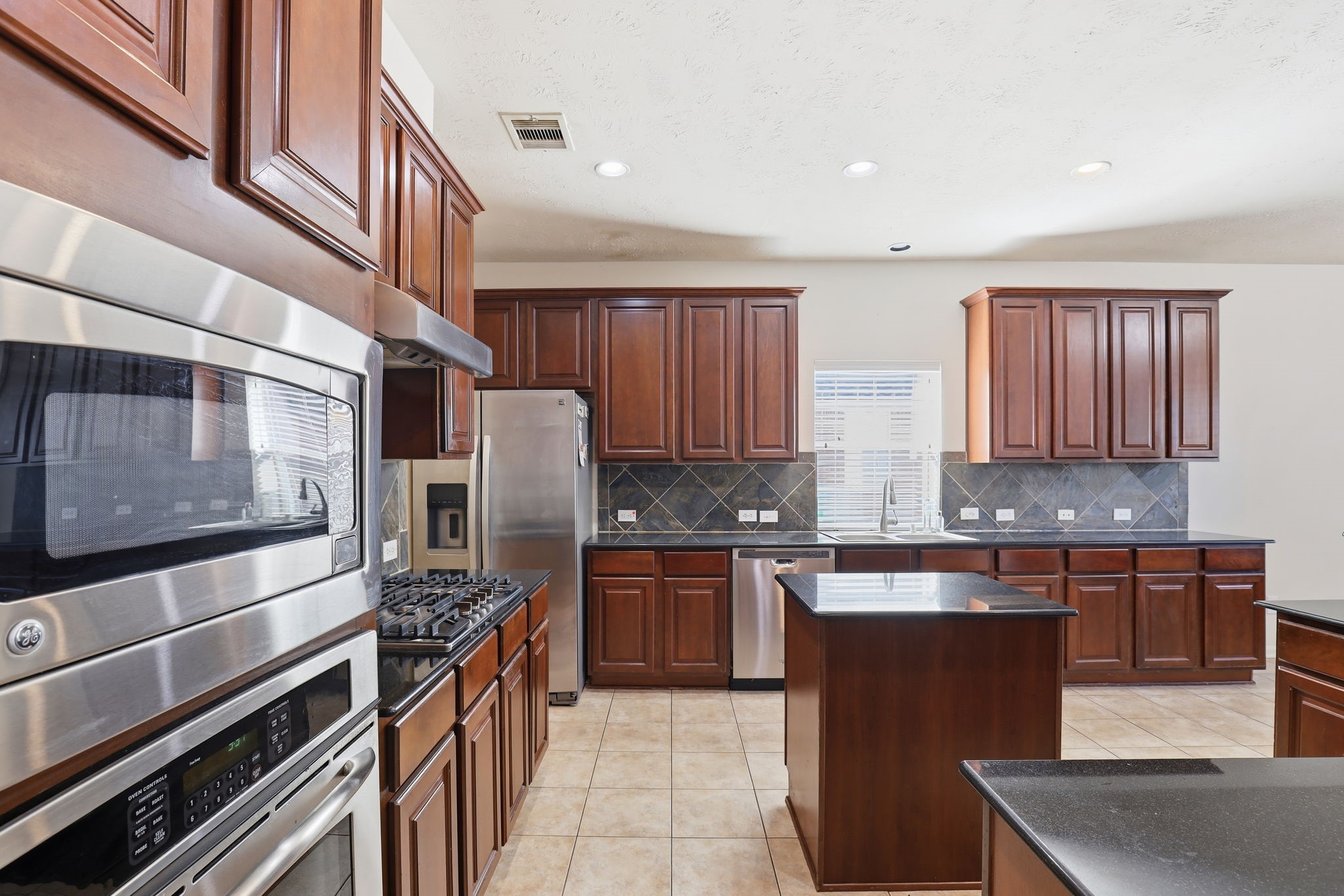 30615 Winlock Trails Drive Spring, TX 77386 - Photo 7 of 33 a kitchen with stainless steel appliances granite countertop a stove top oven a sink and dishwasher