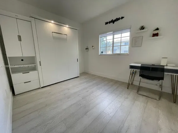 a workspace with wooden floor and windows