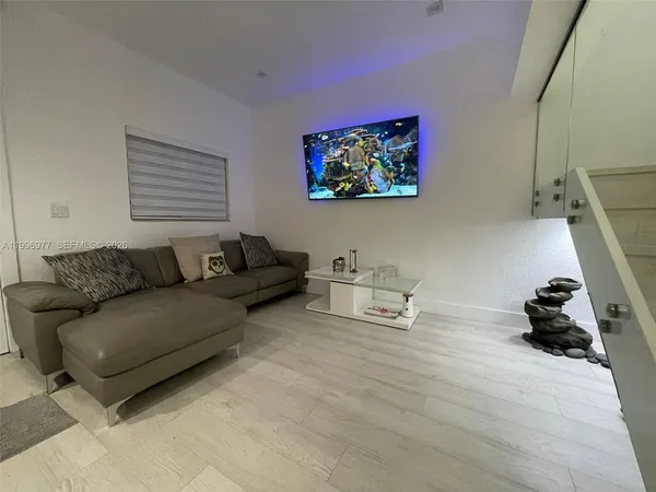 a living room with furniture and a wooden floor