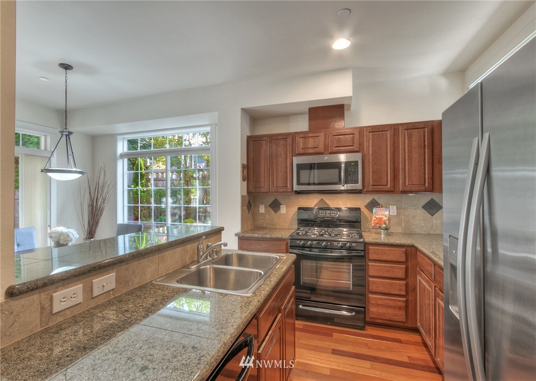 902 225th Place Southeast Bothell, WA 98021 - Photo 4 of 20 a kitchen with kitchen island granite countertop a stove sink and refrigerator