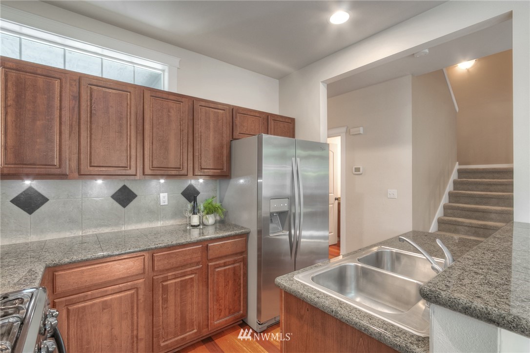 902 225th Place Southeast Bothell, WA 98021 - Photo 5 of 20 a kitchen with granite countertop a sink and a refrigerator