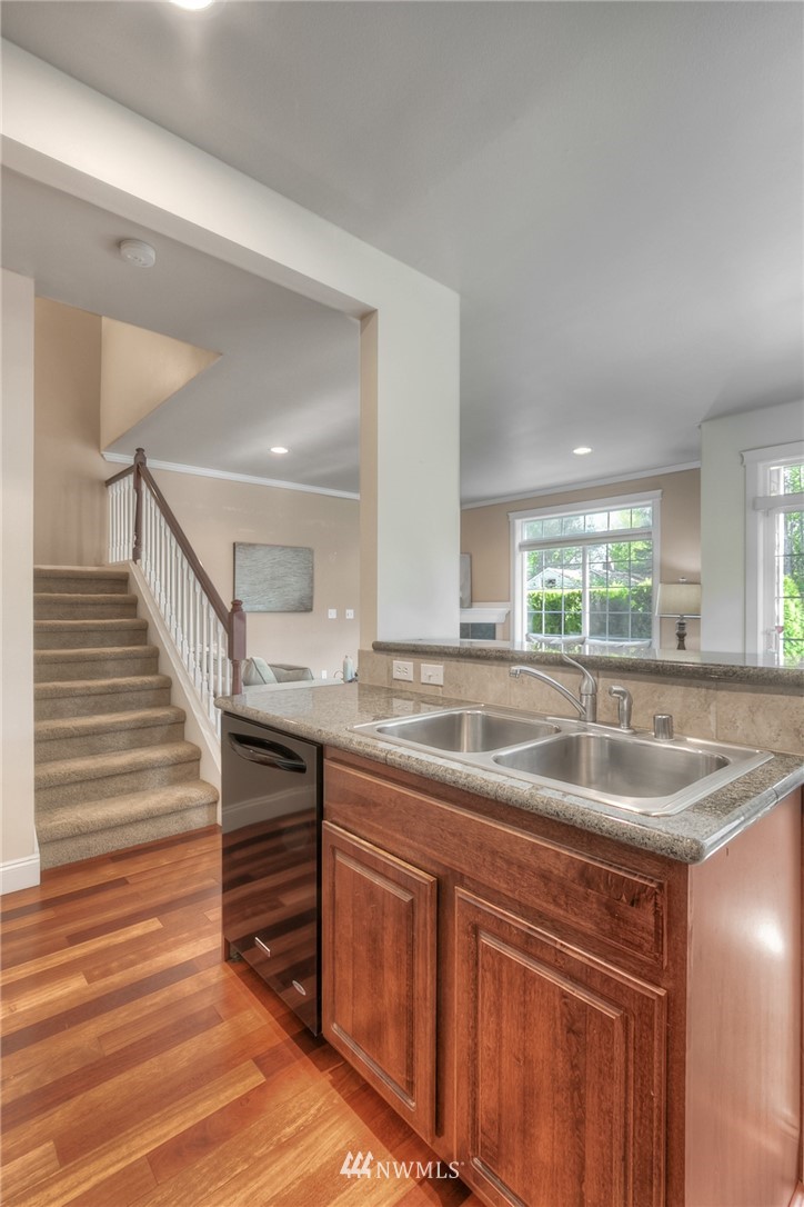 902 225th Place Southeast Bothell, WA 98021 - Photo 6 of 20 a kitchen with kitchen island granite countertop a sink and dishwasher with wooden floor