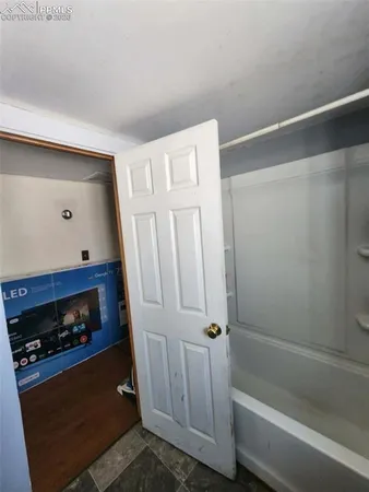 a bathroom with a tub and a wooden floor