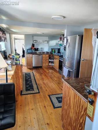 a kitchen with stainless steel appliances granite countertop a refrigerator sink and stove