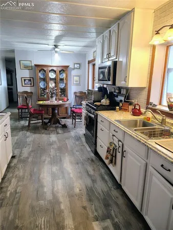 a kitchen with stainless steel appliances granite countertop a lot of counter space and wooden floors