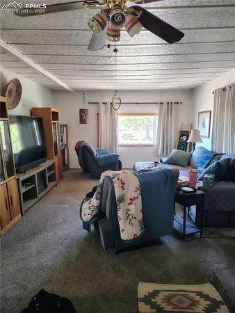 a living room with furniture a window and a flat screen tv