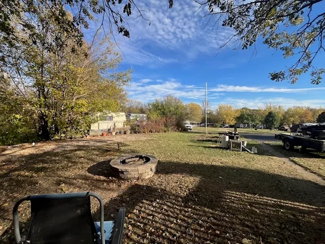 a view of a yard with cars parked on the road
