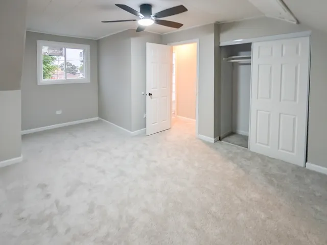 en empty room with ceiling fan and window