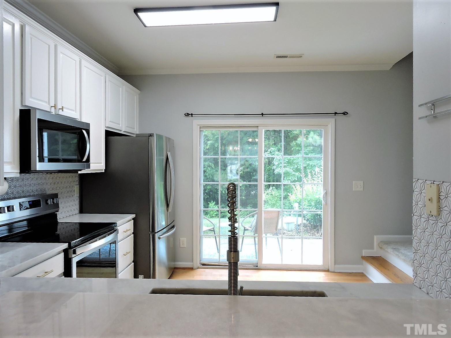 3811 Ramblewood Avenue Durham, NC 27713 - Photo 14 of 29 a kitchen with stainless steel appliances a refrigerator and a stove top oven