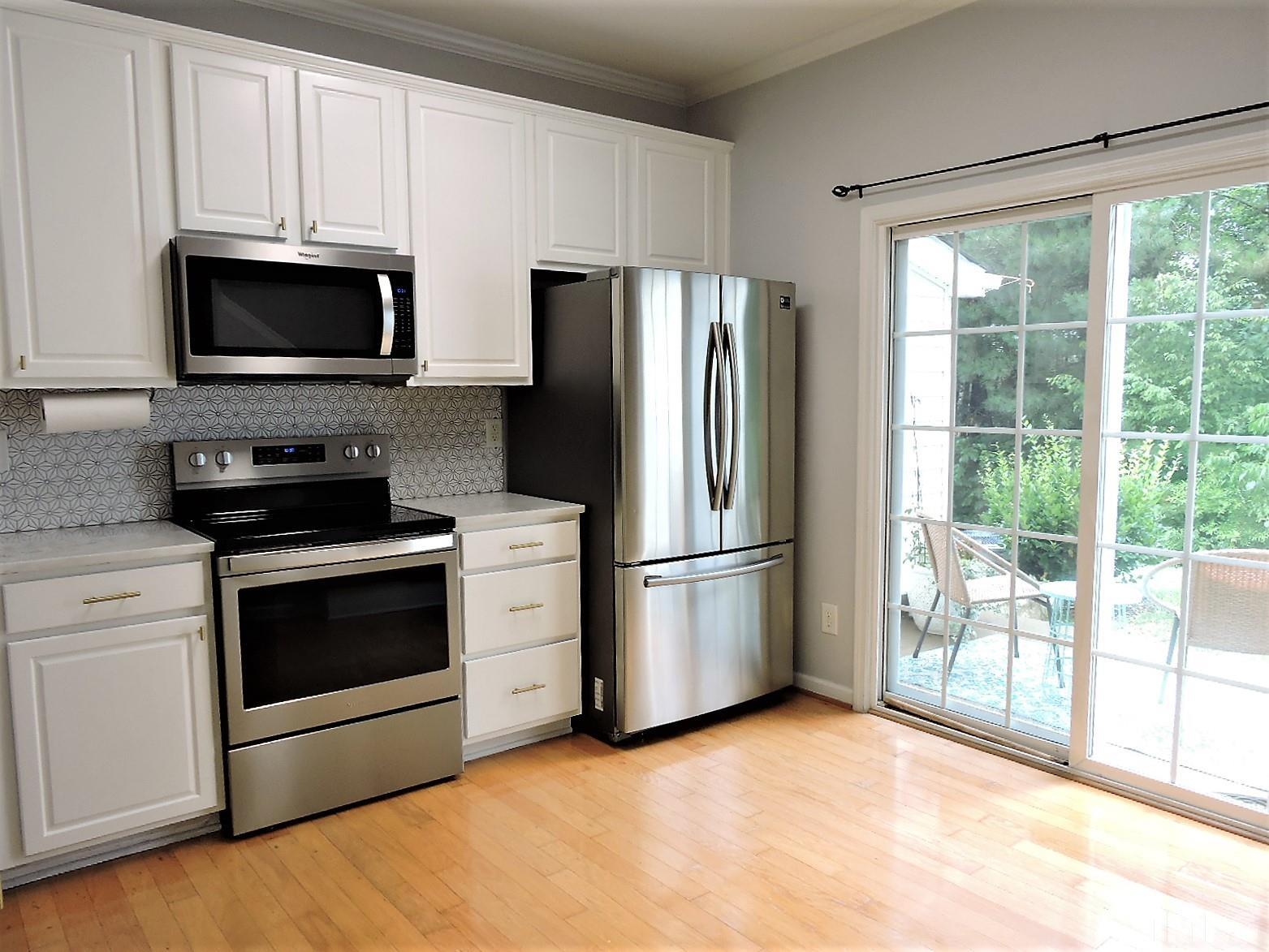 3811 Ramblewood Avenue Durham, NC 27713 - Photo 15 of 29 a kitchen with stainless steel appliances a refrigerator stove and microwave