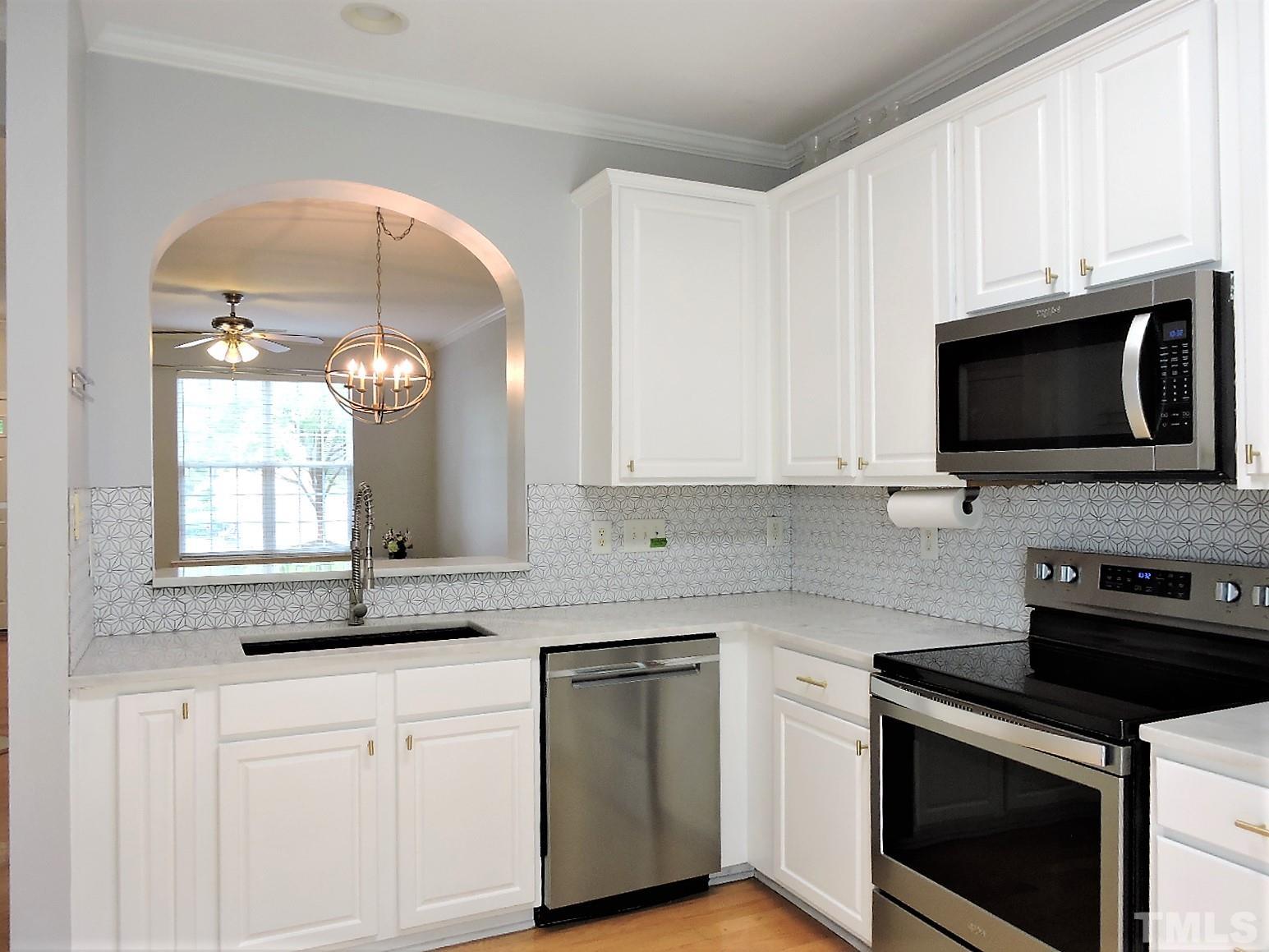 3811 Ramblewood Avenue Durham, NC 27713 - Photo 17 of 29 a kitchen with granite countertop white cabinets stainless steel appliances and sink
