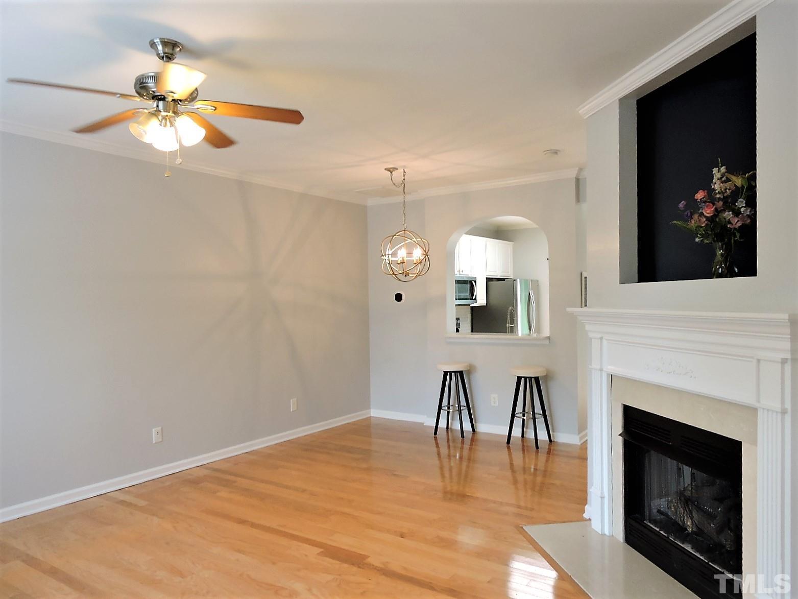3811 Ramblewood Avenue Durham, NC 27713 - Photo 5 of 29 a view of a livingroom with a fireplace a chandelier and wooden floor